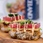 Delicate sushi rolls with tuna, avocado, and cucumber on a wooden board with a blurred background.